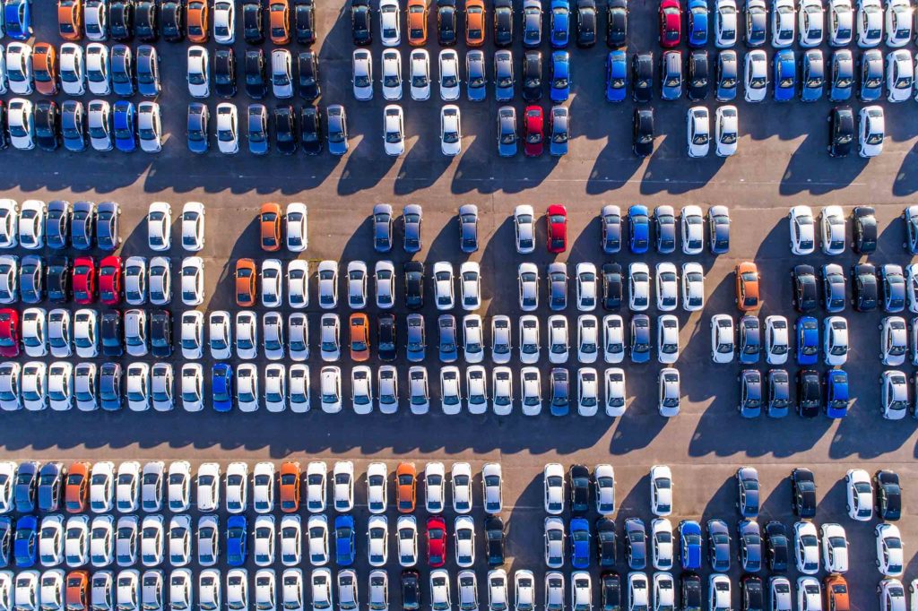 Hundreds of cars on a lot, viewed from above