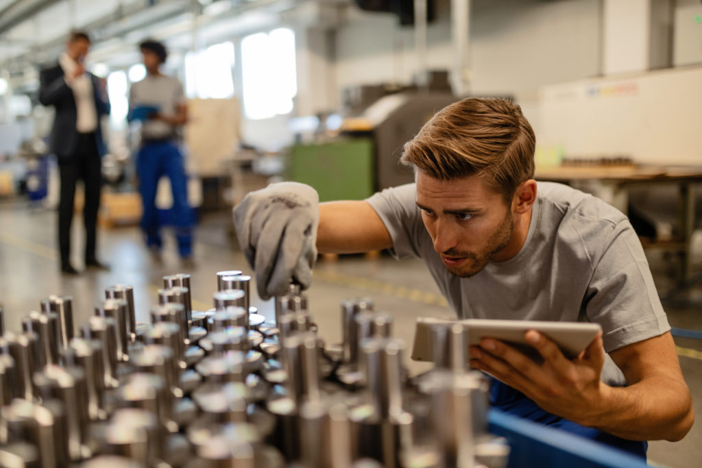 Person checking tolerances in machined parts